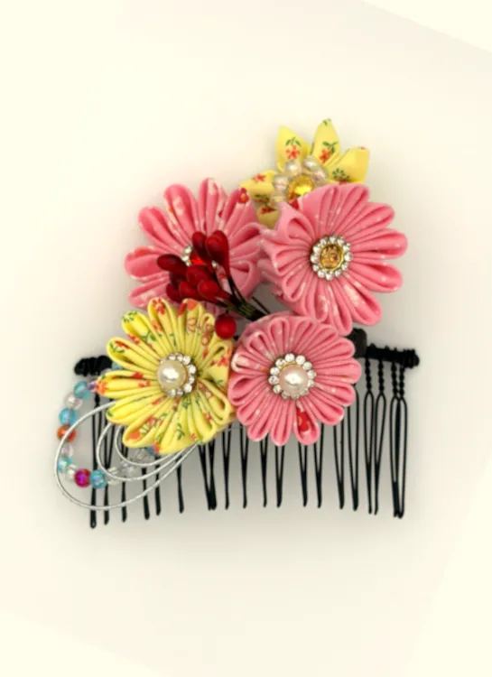 ピンクとイエローの花に赤い実を添え、繊細なビーズループで仕上げたやさしい印象のヘアコームです。