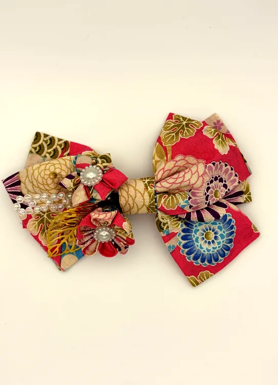 菊柄を重ねた赤い生地のリボンに、つまみ細工の小花とパールを添えた華やかな一品。